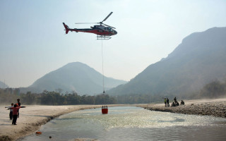 दमौलीमा आगो निभाउन मादीबाट पानी ओसार्दै हेलिकप्टर