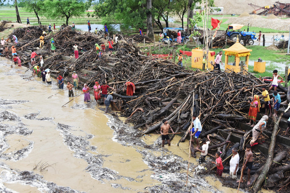 सिधनवा घाटमा जोखिम मोलेर नदीबाट दाउरा झिक्दै स्थानीय